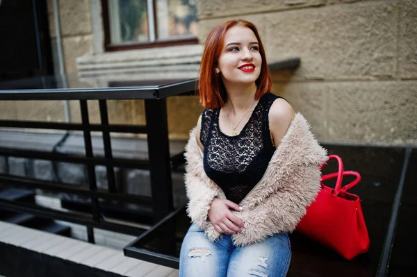 Chica pelirroja con bolso rojo posado en la calle de la ciudad . — Foto de Stock