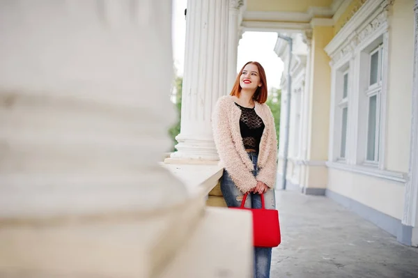 Fille aux cheveux rouges avec sac à main rouge posé près de la maison vintage . — Photo