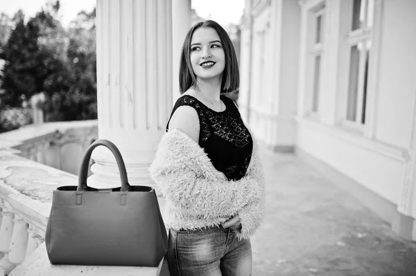 Menina de cabelos vermelhos com bolsa vermelha posou perto da casa do vintage . — Fotografia de Stock