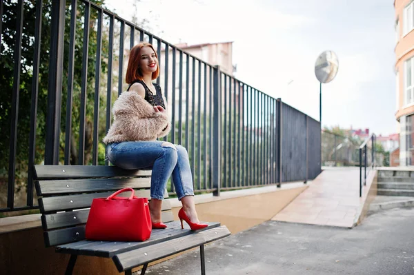 Chica pelirroja con bolso rojo posado en el banco . —  Fotos de Stock