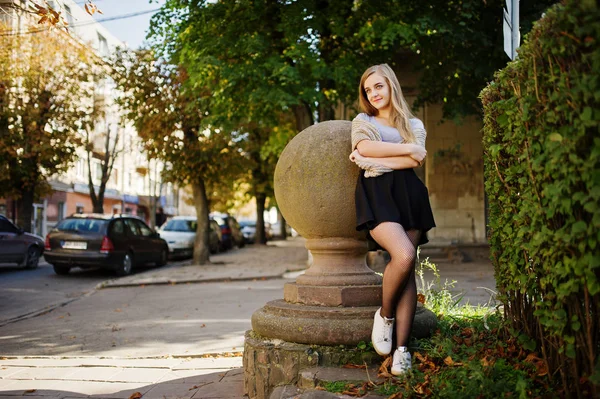 Junges blondes Mädchen in schwarzem Rock mit Schal posierte auf der Straße von c — Stockfoto