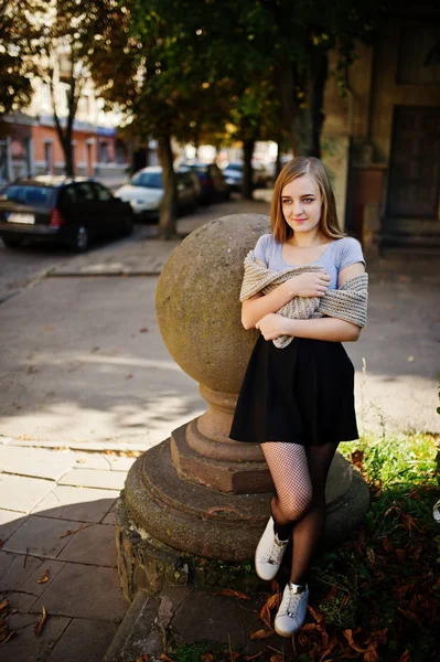 Ung blond tjej i svart kjol med halsduk poserade på street c — Stockfoto