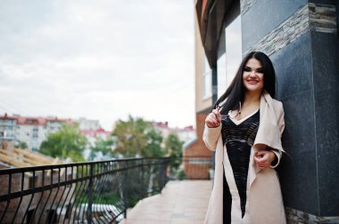 Siyah saçlı seksi kadın gözlük ve kat bina karşı poz verdi.