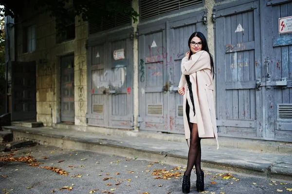 Frau mit schwarzem Haar, Brille und Mantel posierte auf der Straße. — Stockfoto