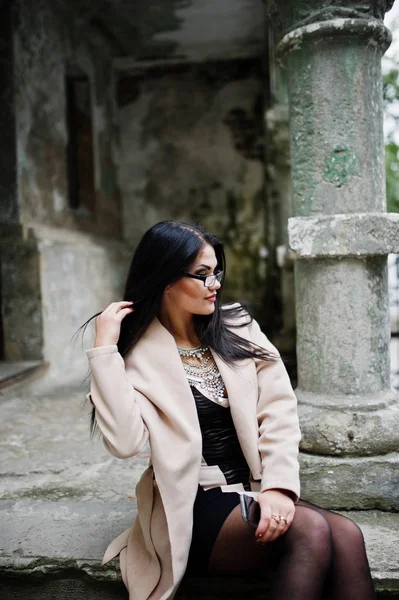 Black hair sexy woman in glasses and coat posed at street of old — Stock Photo, Image