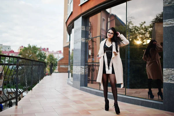 Schwarze Haare sexy Frau mit Brille und Mantel posierte gegen Gebäude — Stockfoto