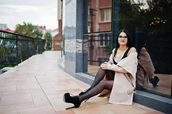 Fekete hajú szexi nő szemüveg és kabát szemben épület — Stock Fotó