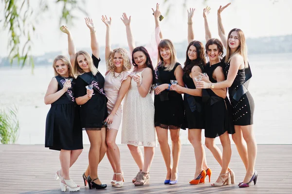 Group of 8 girls wear on black and 2 brides at hen party against — Stock Photo, Image