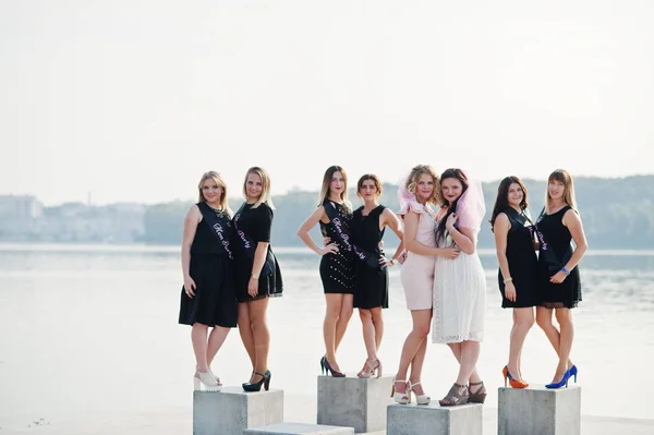 Group of 8 girls wear on black and 2 brides at hen party against — Stock Photo, Image