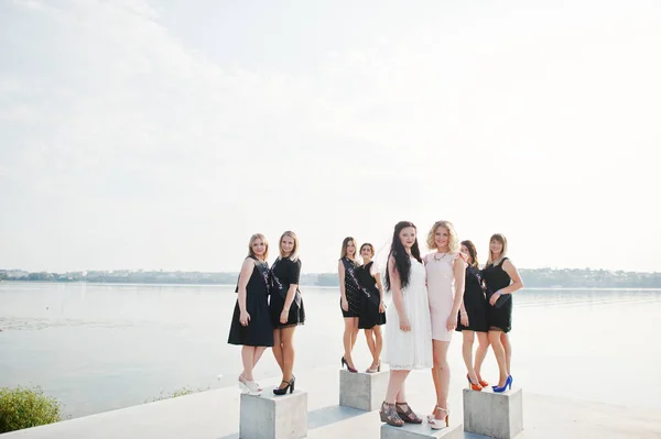 Gruppo di 8 ragazze vestite di nero e 2 spose alla festa di addio al nubilato contro — Foto Stock