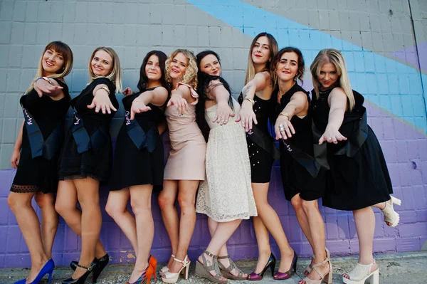 Group of 8 girls wear on black and 2 brides at hen party against — Stock Photo, Image