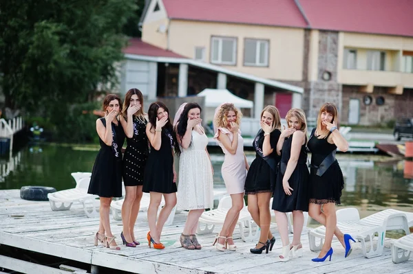 Group of 8 girls wear on black and 2 brides at hen party at pier — Stock Photo, Image