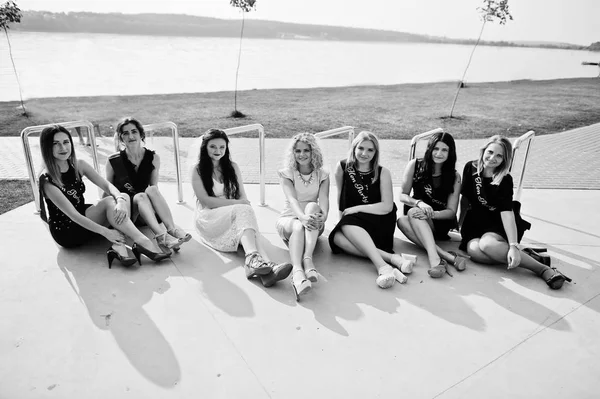 Група з 7 дівчат одягнені на чорному і 2 наречених сидять на фоні l — стокове фото
