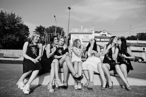 Grupa 7 dziewczyn nosi na czarny i 2 narzeczonych, siedząc na ławce i — Zdjęcie stockowe
