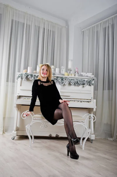 Draguta blonda fata pe negru rochie împotriva nou an pian cu chri — Fotografie, imagine de stoc