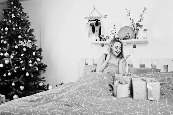 Милая блондинка на черном лифчике лежит на кровати с подарочными коробками agai — стоковое фото