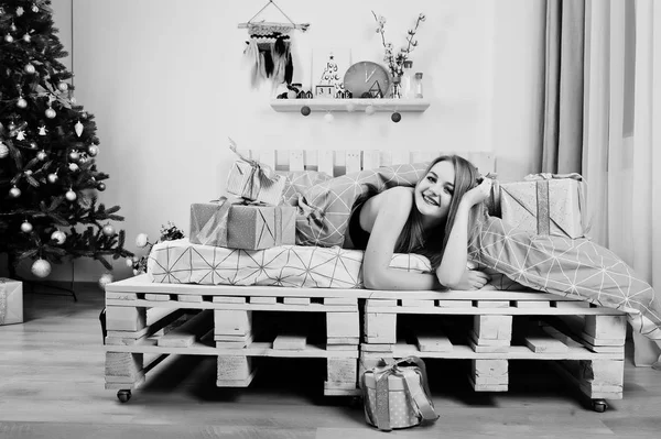 Jolie fille blonde sur le soutien-gorge noir couché sur le lit avec des boîtes-cadeaux agai — Photo