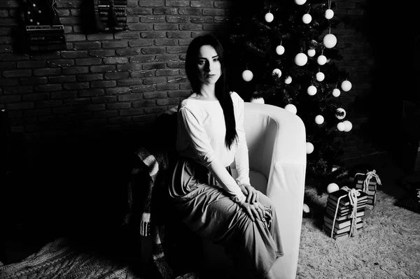 Брюнетка в платье позировала возле новогодней елки с Рождеством — стоковое фото