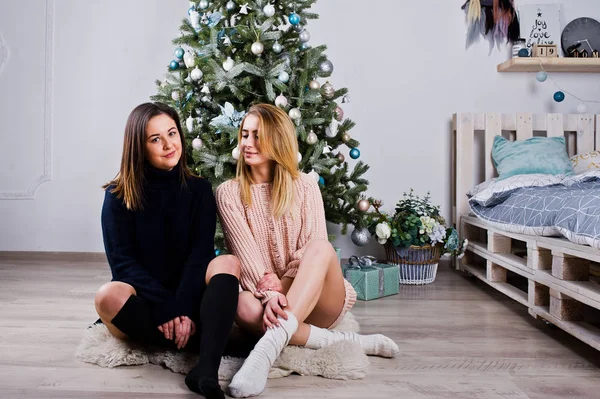 Δύο όμορφα κορίτσια φίλους να φοράτε ζεστά πουλόβερ και πόδι θερμοκοιτίδων — Φωτογραφία Αρχείου
