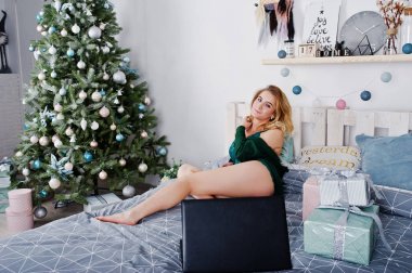 Cep telefonu ile yatakta yeşil iç çamaşırı seksi sarışın model ve