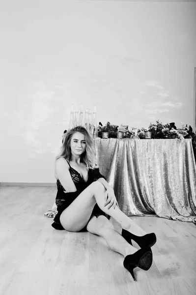 Sexy modelo rubia en lencería negra y tacones altos contra mesa —  Fotos de Stock