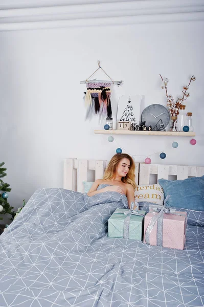 Sexy model blondynka nago na łóżku z pudełka Boże Narodzenie przed — Zdjęcie stockowe