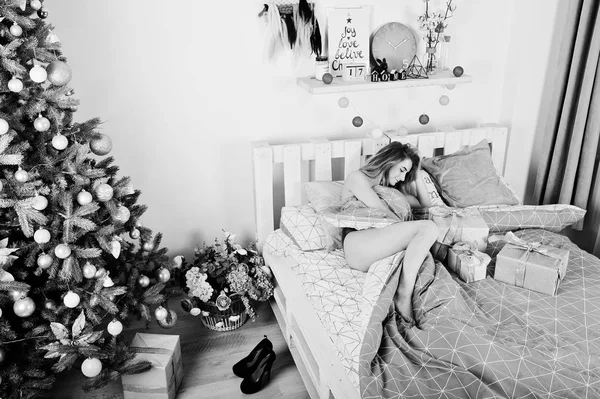 Sexy modèle blonde nue sur le lit avec des boîtes-cadeaux de Noël contre — Photo