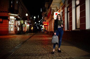 Gece portresi kız modeli giyim gözlük, kot pantolon ve deri 