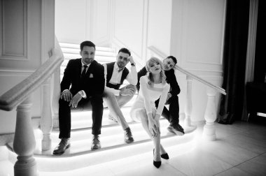 Üç şık sakallı adam iyi bir sarışın kız w ile giyinmiş.