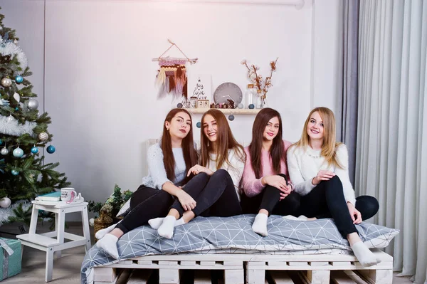 Cuatro amigas lindas que usan suéteres calientes y pantalones negros —  Fotos de Stock