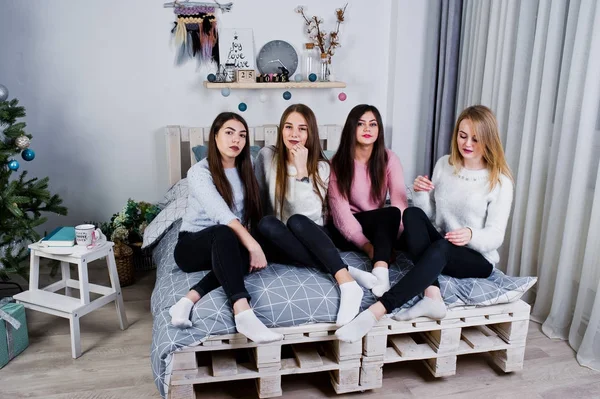 Cuatro amigas lindas que usan suéteres calientes y pantalones negros —  Fotos de Stock