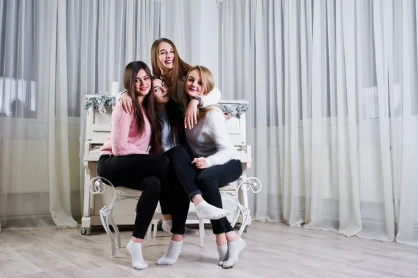 Vier süße Freundinnen tragen warme Pullover und schwarze Hosen. — Stockfoto