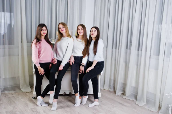 Fyra söta vänner tjejer slitage på varma tröjor och svarta byxor ag — Stockfoto
