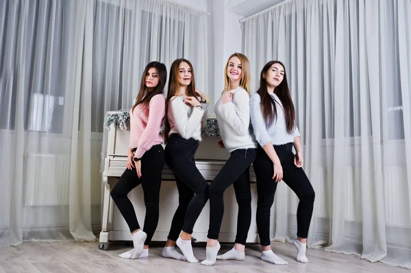 Vier süße Freundinnen tragen warme Pullover und schwarze Hosen. — Stockfoto