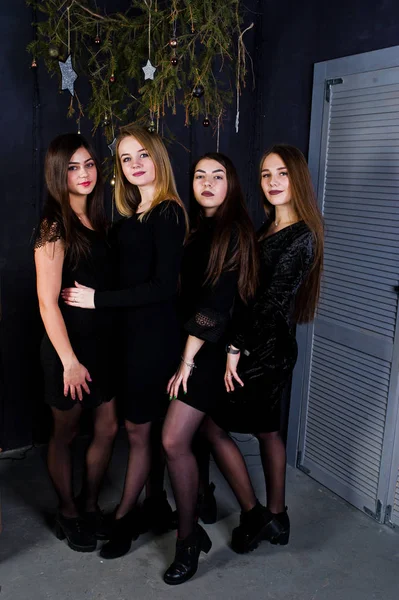 Čtyři dívky roztomilý přátelé nosí černé šaty proti vánoční prosinec — Stock fotografie