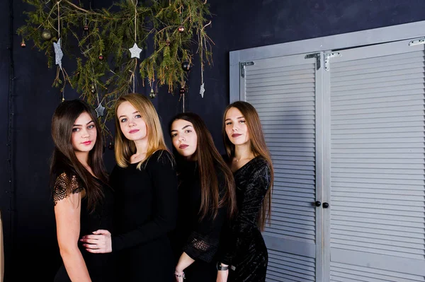 Four cute friends girls wear black dresses against christmas dec — Stock Photo, Image