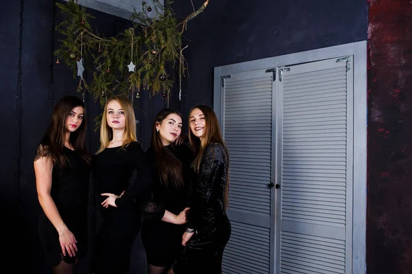 Cuatro amigas lindas usan vestidos negros contra la Navidad dec —  Fotos de Stock