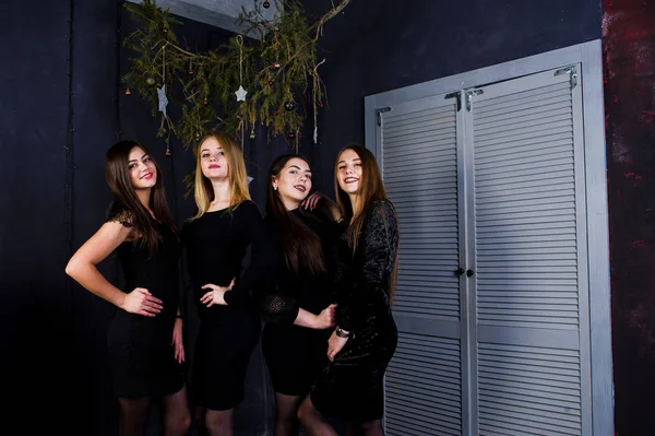 Quatro amigos bonitos meninas usam vestidos pretos contra o Natal dec — Fotografia de Stock