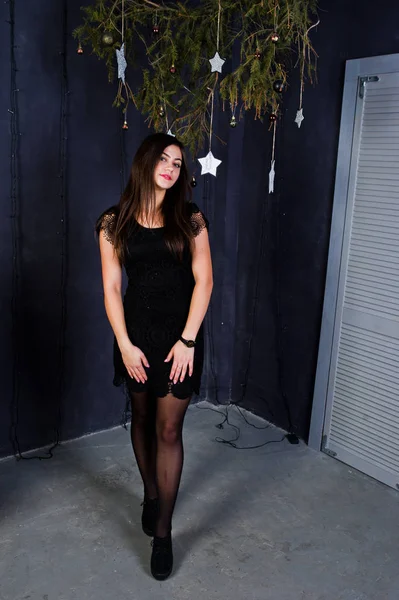 Aranyos lány viselni a fekete ruha ellen karácsonyi dekoráció. — Stock Fotó