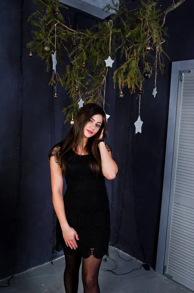Linda chica desgaste en vestido negro contra la decoración de Navidad . —  Fotos de Stock