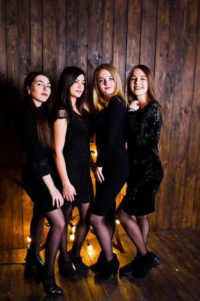 Quatro amigos bonitos meninas usam vestidos pretos contra a grande luz c — Fotografia de Stock