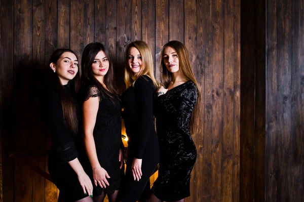 Чотири милі друзі дівчата носять чорні сукні проти великого світла c — стокове фото