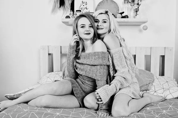 Deux filles blondes élégantes portent sur une tunique chaude assise sur le lit . — Photo
