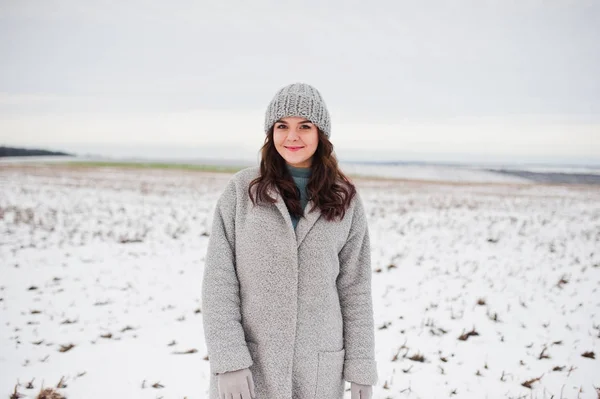 Menina gentil em casaco cinza e chapéu contra a paisagem de neve . — Fotografia de Stock
