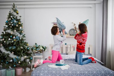 İki kız yatakta roo adlı eğleniyor kış kazak giymek