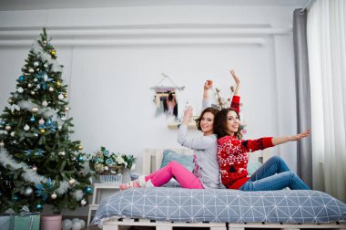 İki kız yatakta roo adlı eğleniyor kış kazak giymek