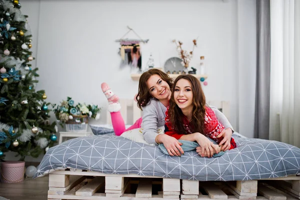两个女朋友穿在冬季毛衣有乐趣在小豆床 — 图库照片