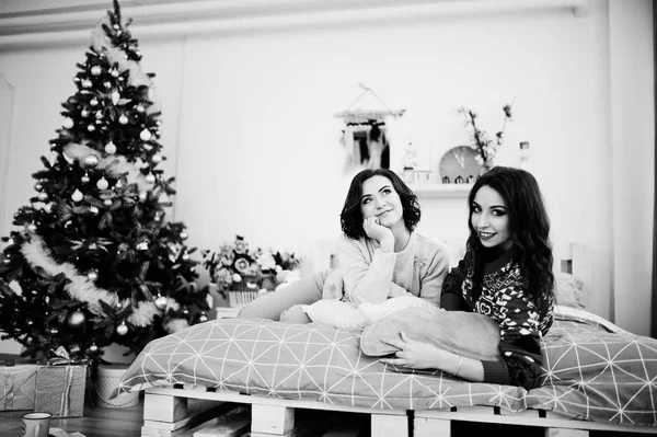 Deux copines portent des pulls d'hiver en s'amusant au lit chez roo — Photo
