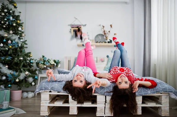 Due amiche indossano maglioni invernali divertendosi sul letto a roo — Foto Stock