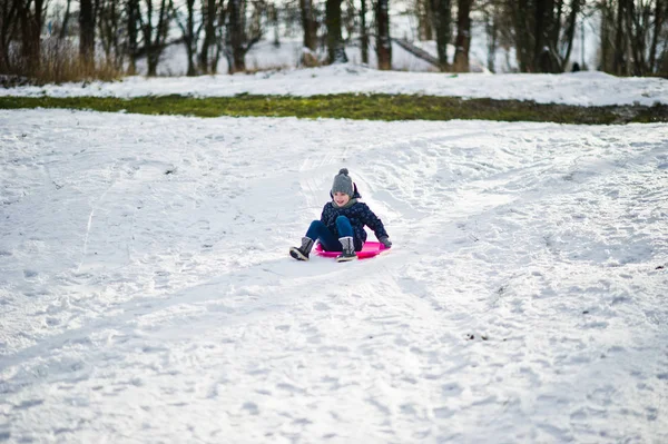 Cute little girl with saucer sleds outdoors on winter day. — Stock Photo, Image